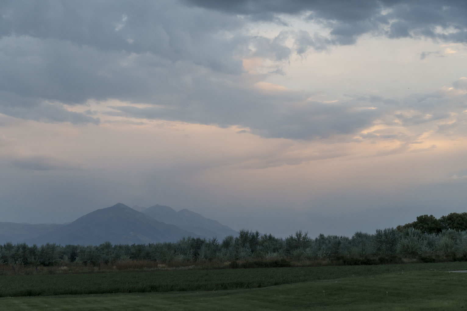 Soft skies above the mountains with looks like Russian olives below